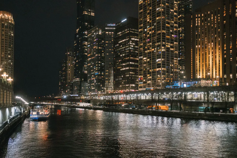 The Chicago River at night with lit office towers on both banks.
